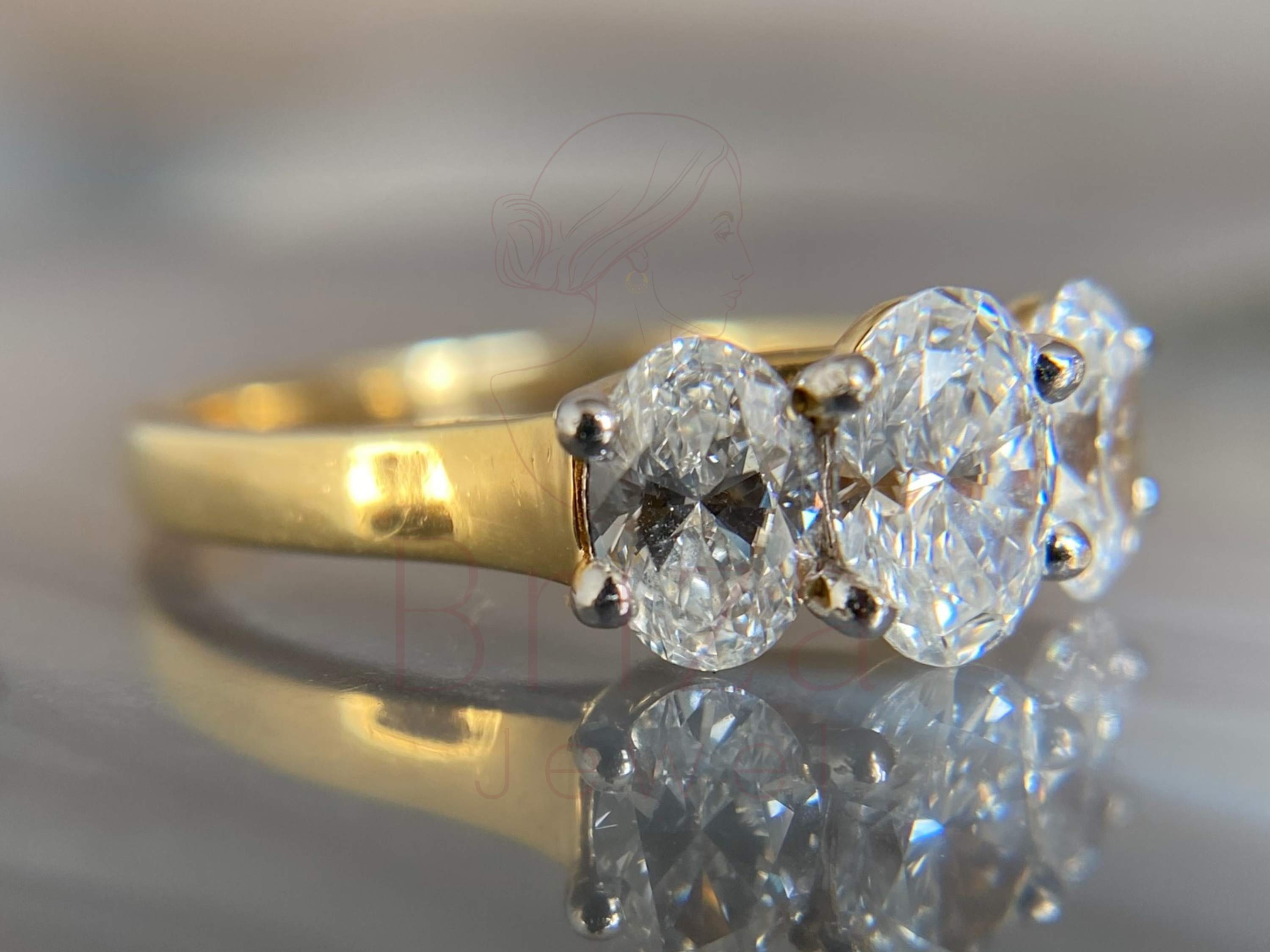 oval center stone flanked by two accent stones in gold