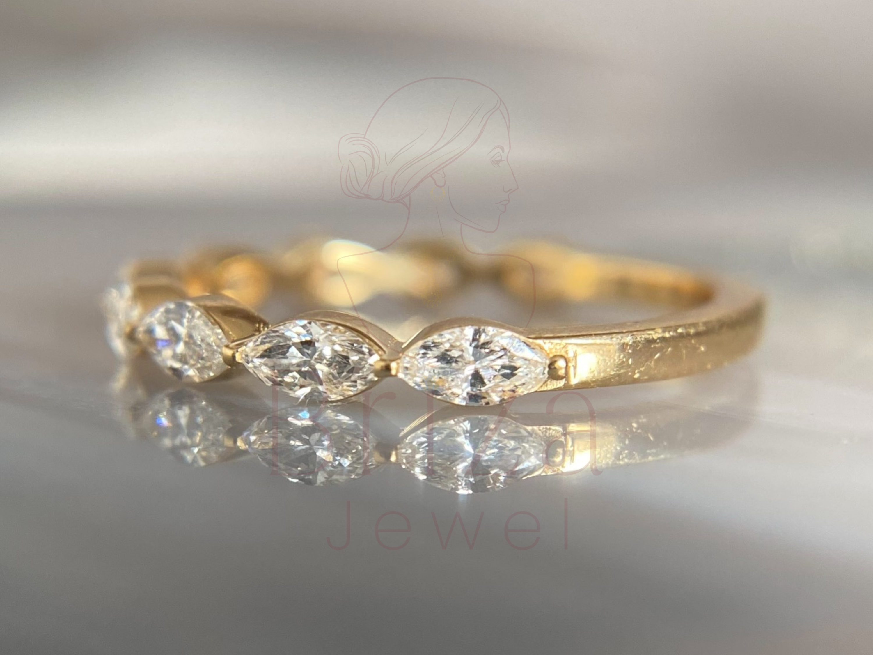 elongated center stone set in a polished gold band