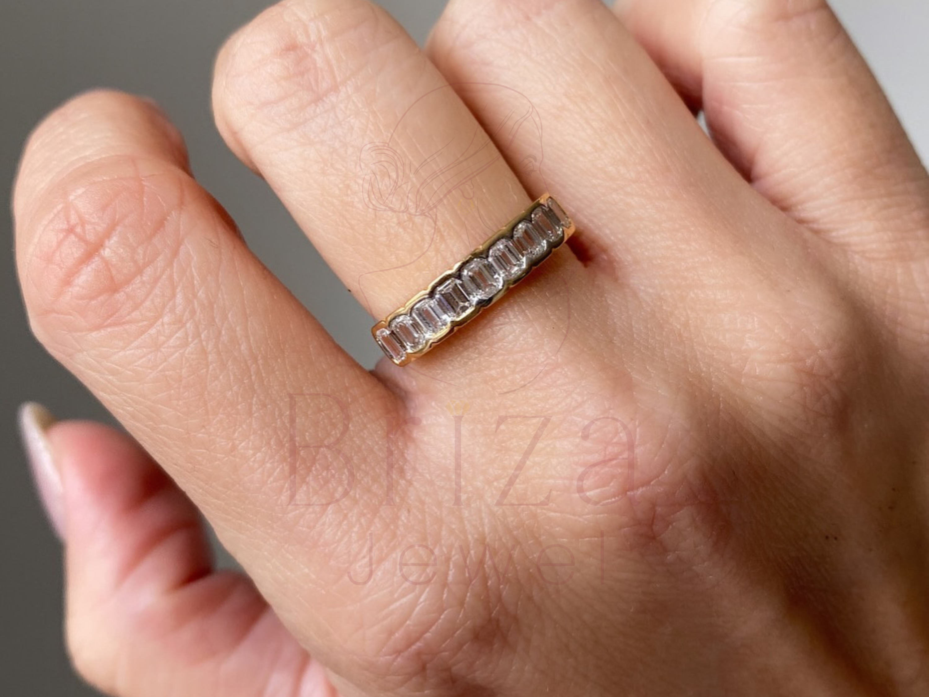 gold eternity wedding band with alternating emeralds and diamonds