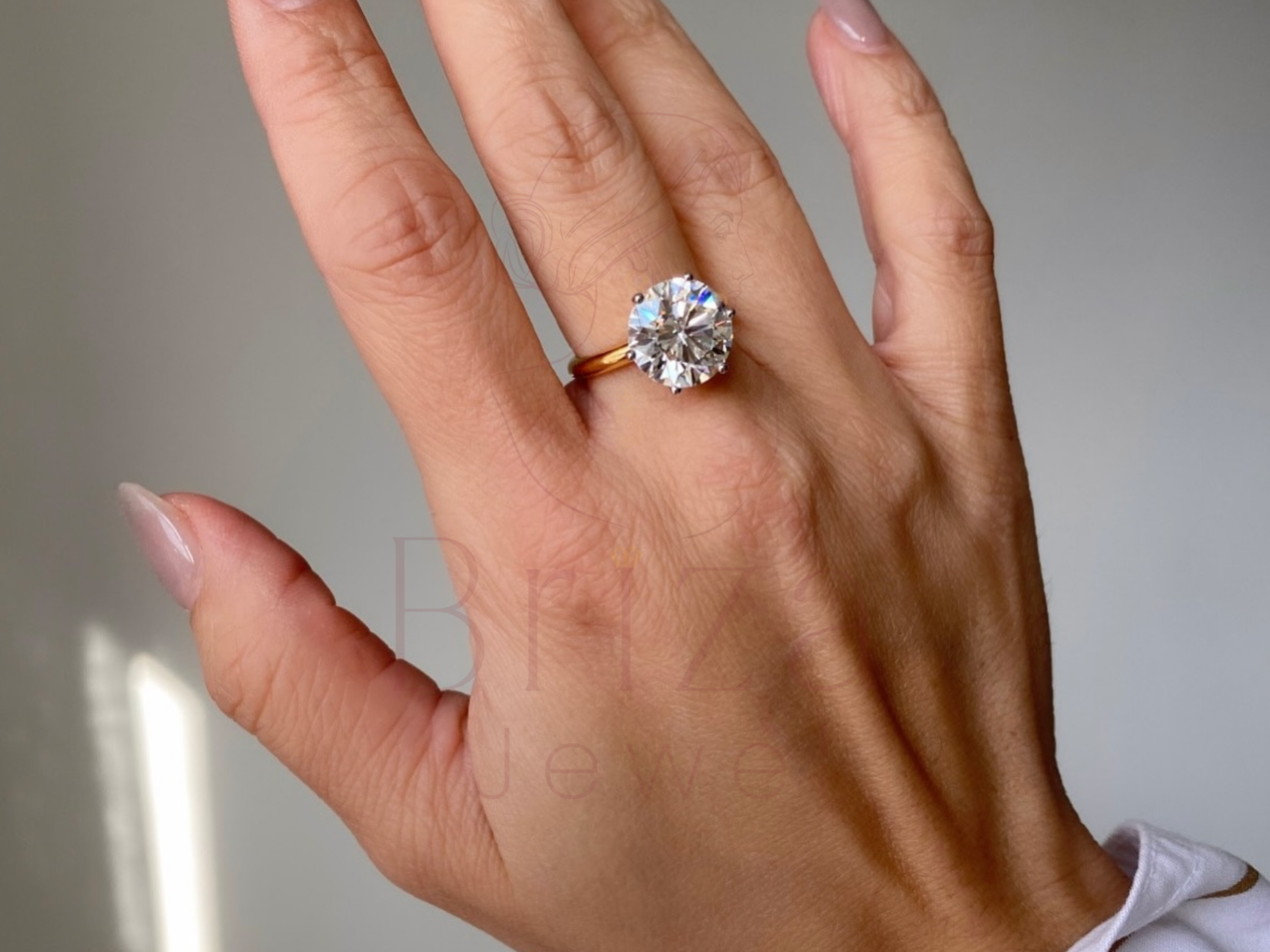 six prong gold setting highlighting a brilliant center stone