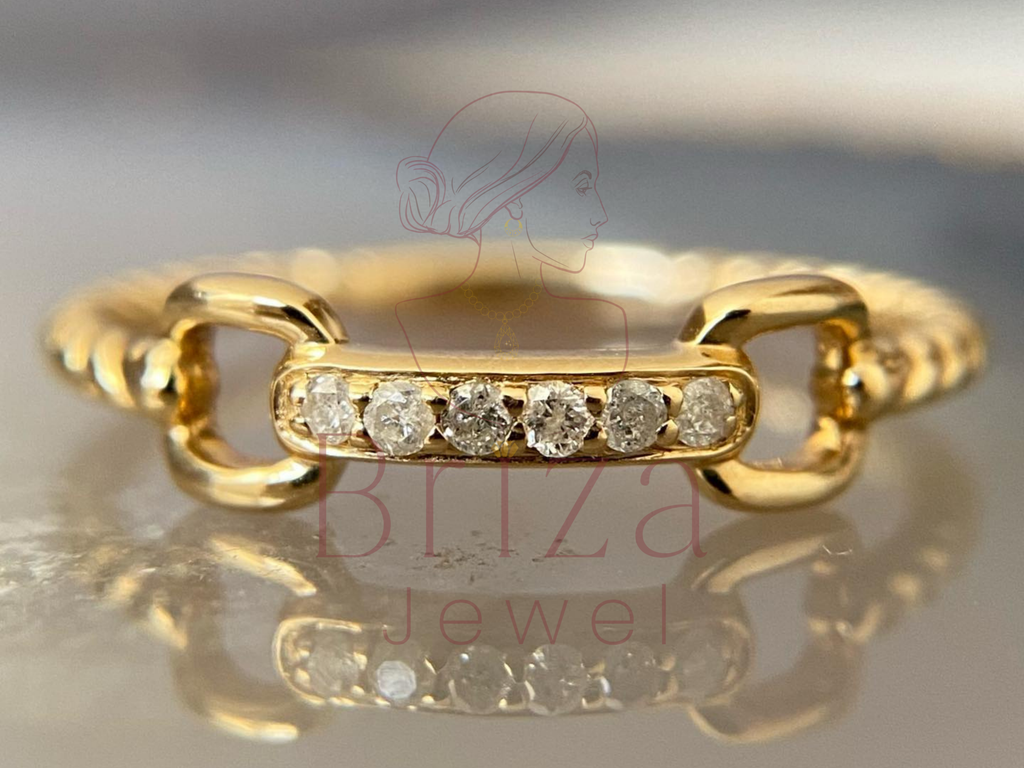 bold statement ring with dainty gold chain and diamond accents
