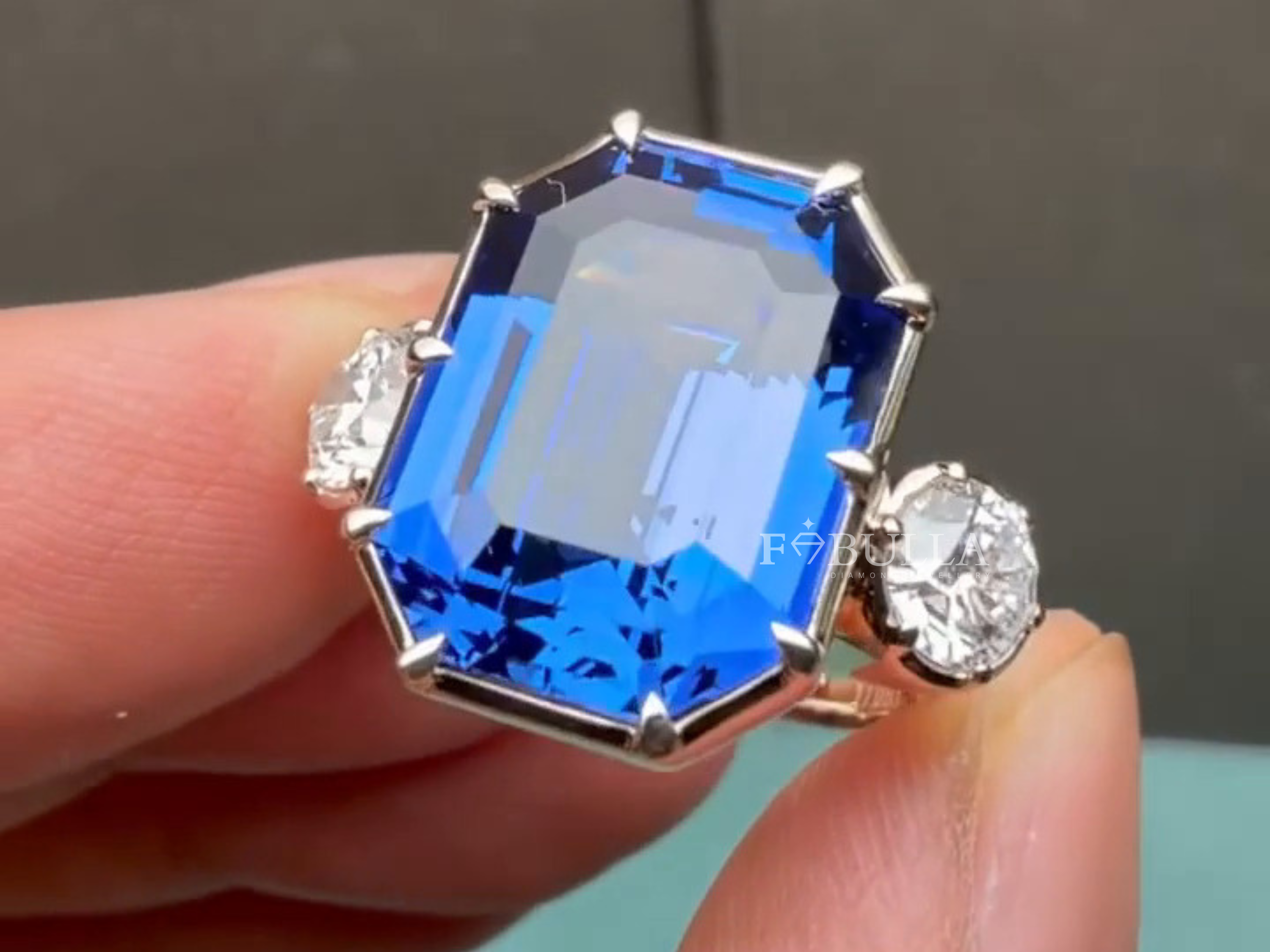 diamond cocktail ring close-up showing emerald cut sapphire detail