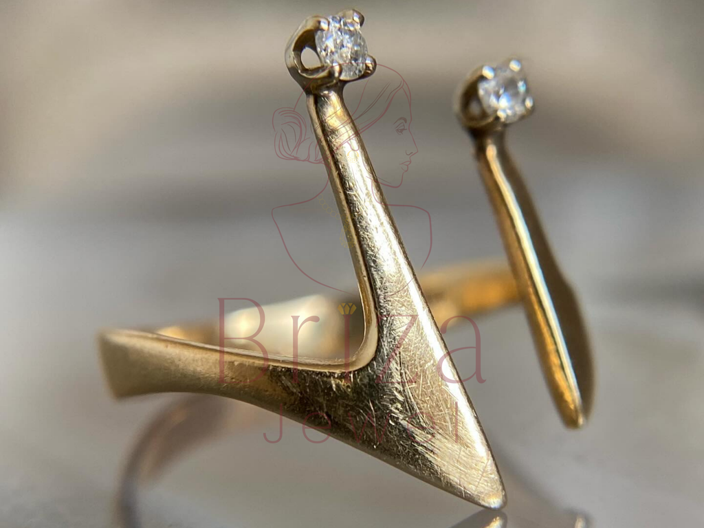 Gold ring with diamond-studded earrings on a blurred background