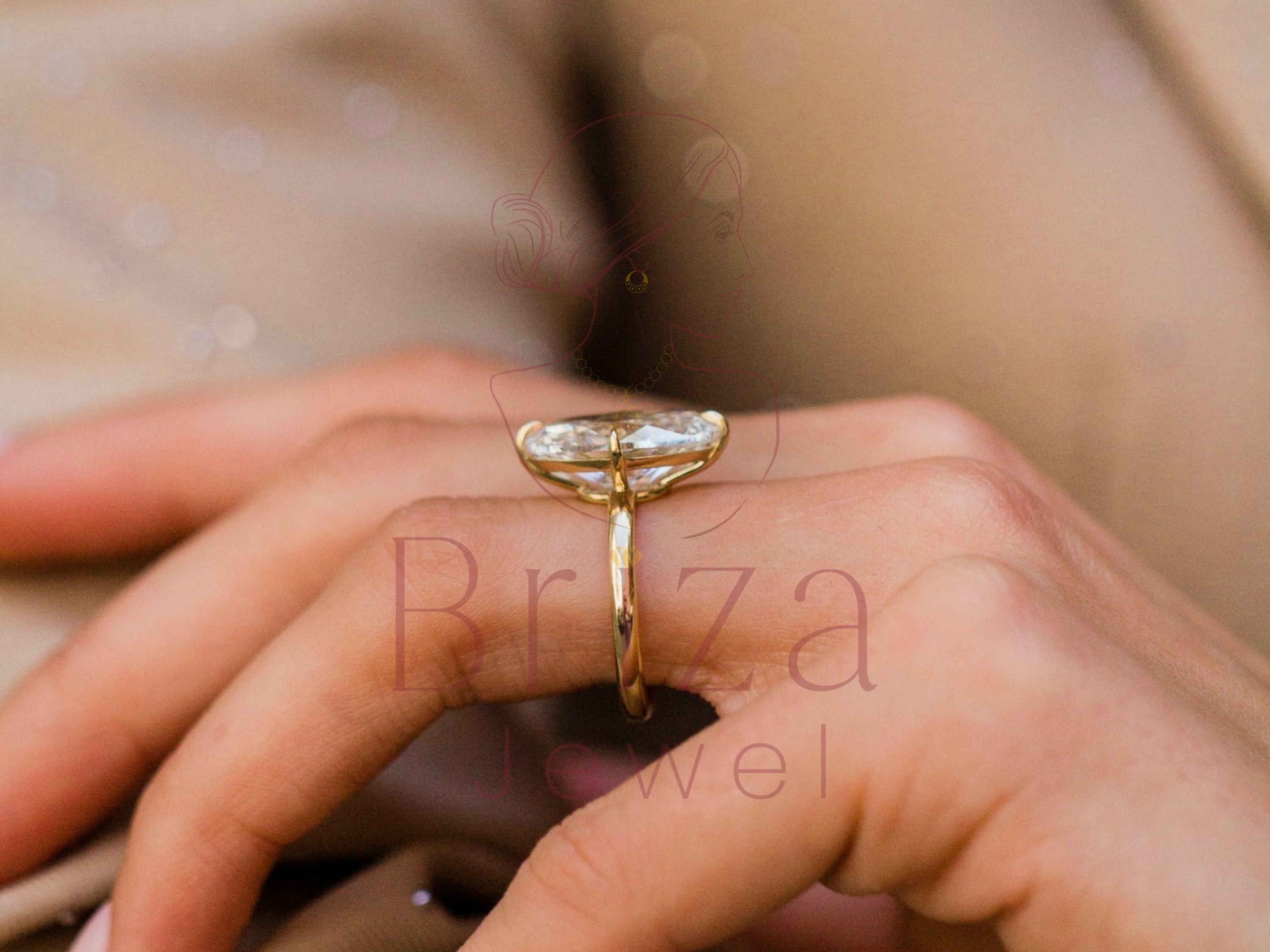 Gold ring with a diamond on a person's finger, brand 'Briza Jewel' visible