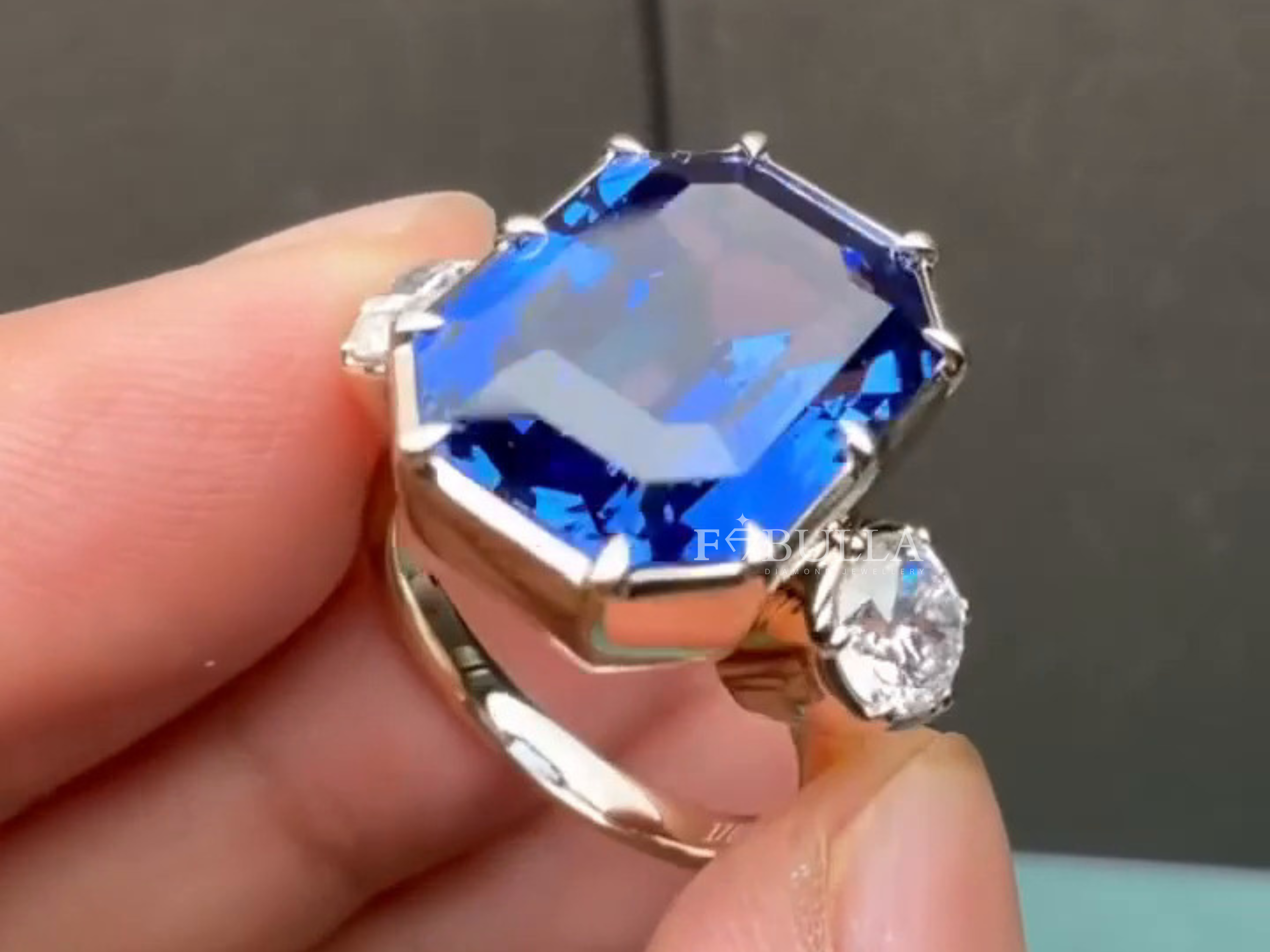 emerald cut blue sapphire surrounded by sparkling accent stones
