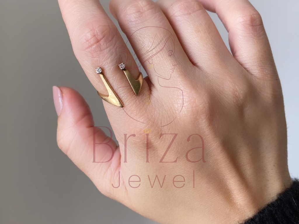 Hand wearing a gold ring with 'Briza Jewel' branding on a neutral background