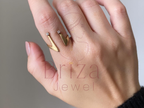 Hand wearing a gold ring with 'Briza Jewel' branding on a neutral background