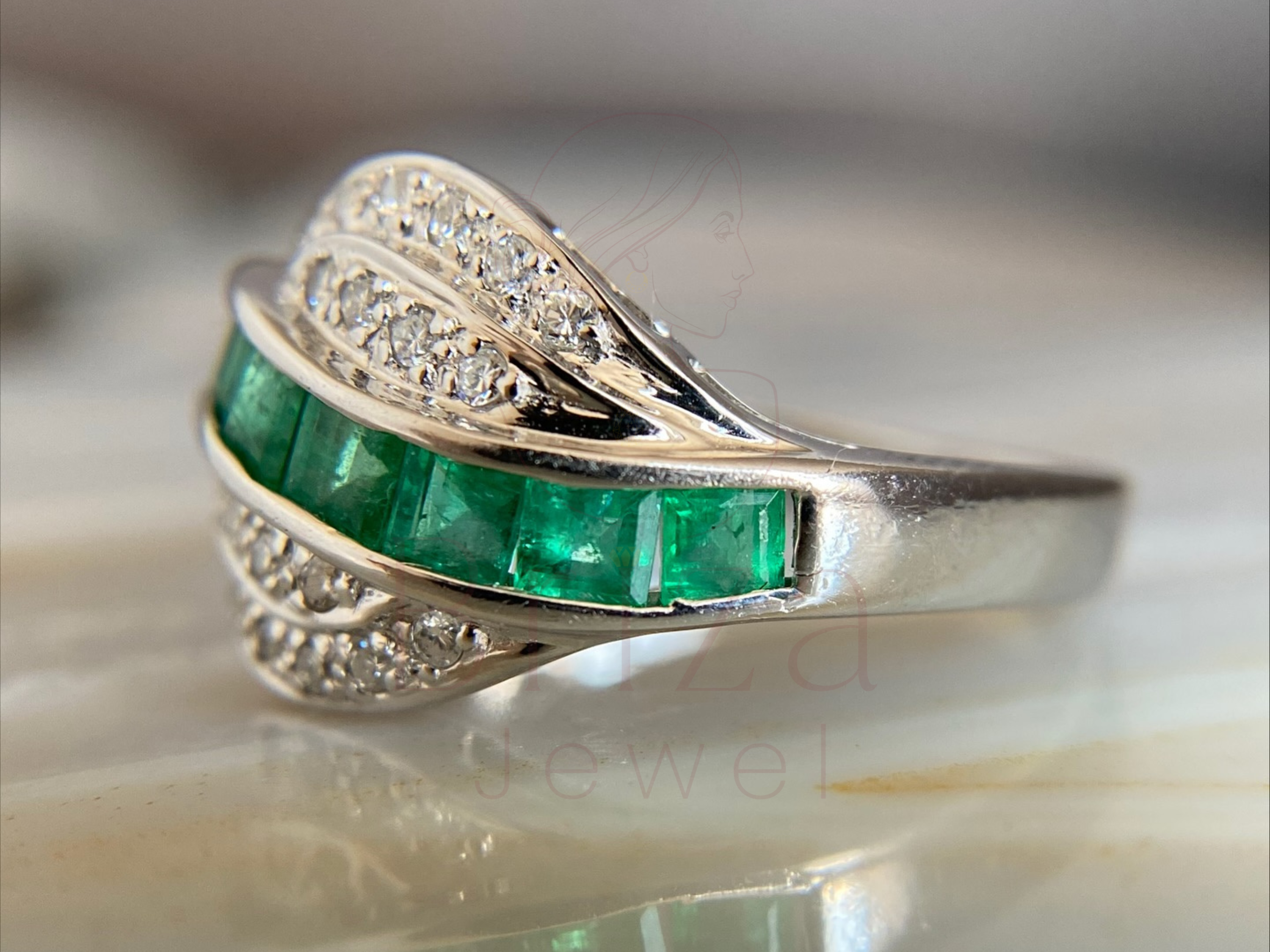 elegant emerald and diamond ring worn on hand