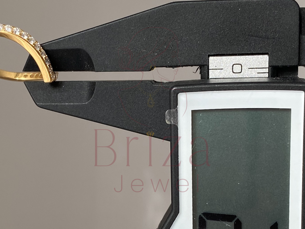 Gold ring being measured with a digital caliper, branded 'Briza Jewelry'.
