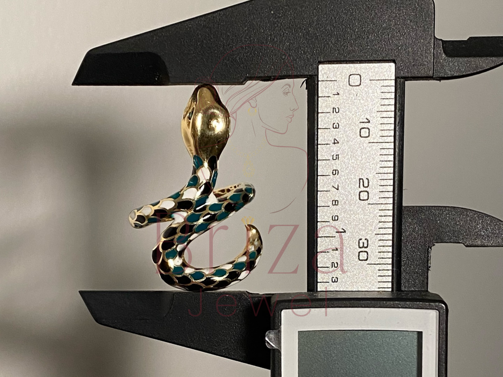 Gold and green snake-shaped earring on a digital caliper for measurement