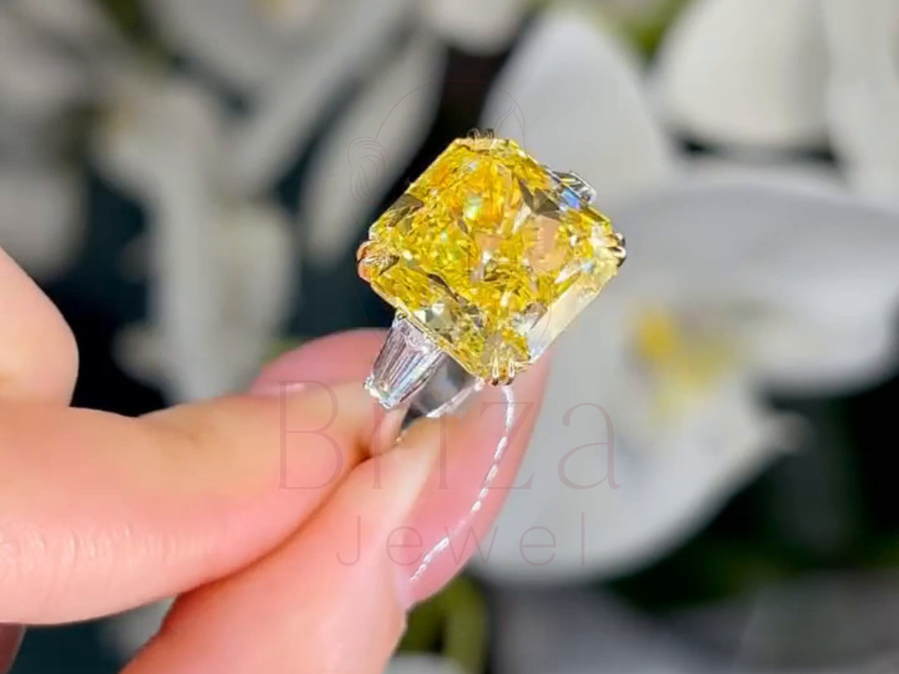 Sparkling yellow diamond held between fingers