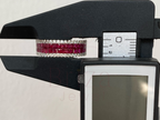 Digital caliper measuring a ruby and diamond bracelet against a white background