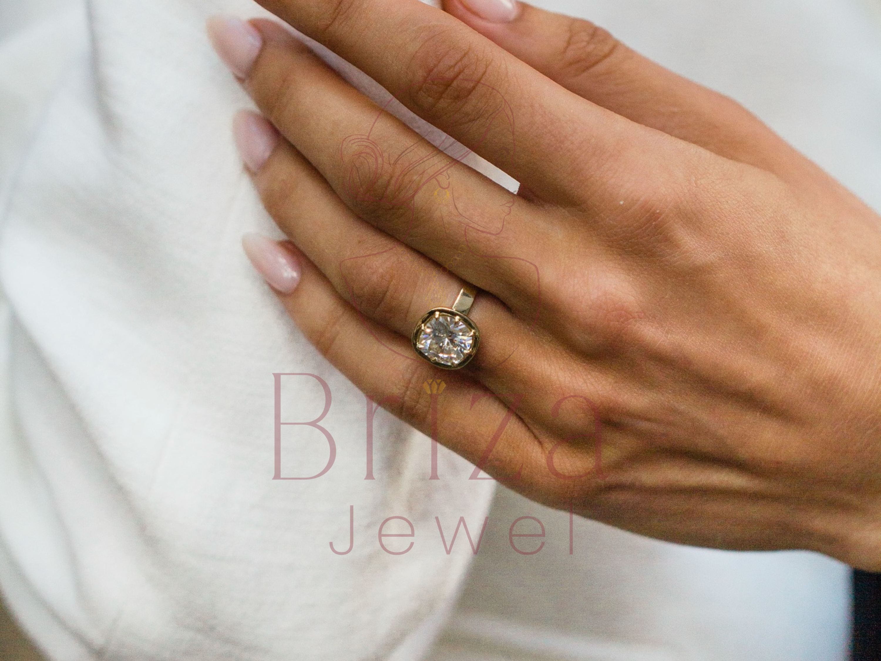 Hand wearing a diamond ring with 'Blige Jewel' branding.
