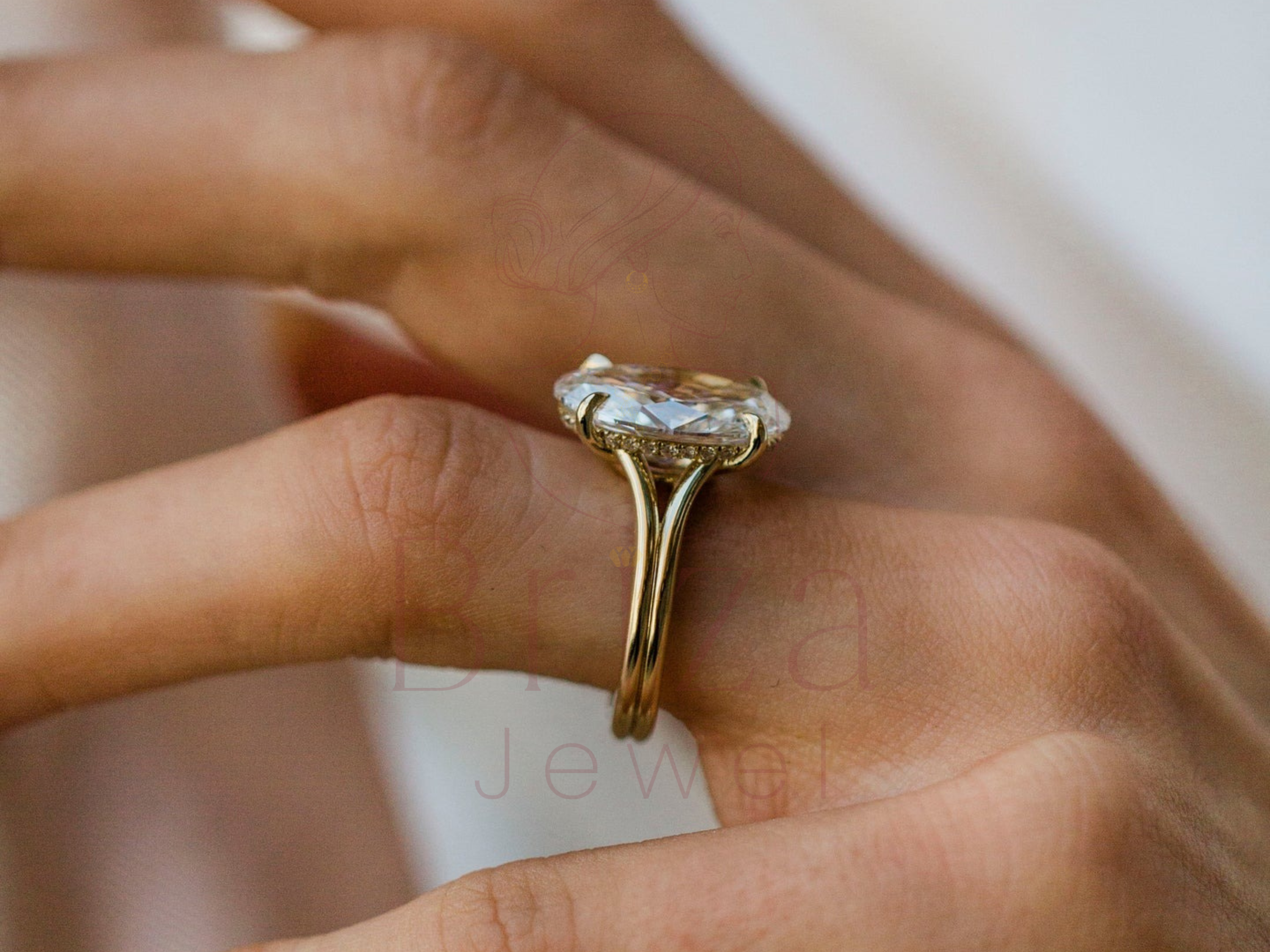 Gold ring with a large diamond on a finger, with 'Boussac' branding in the background.