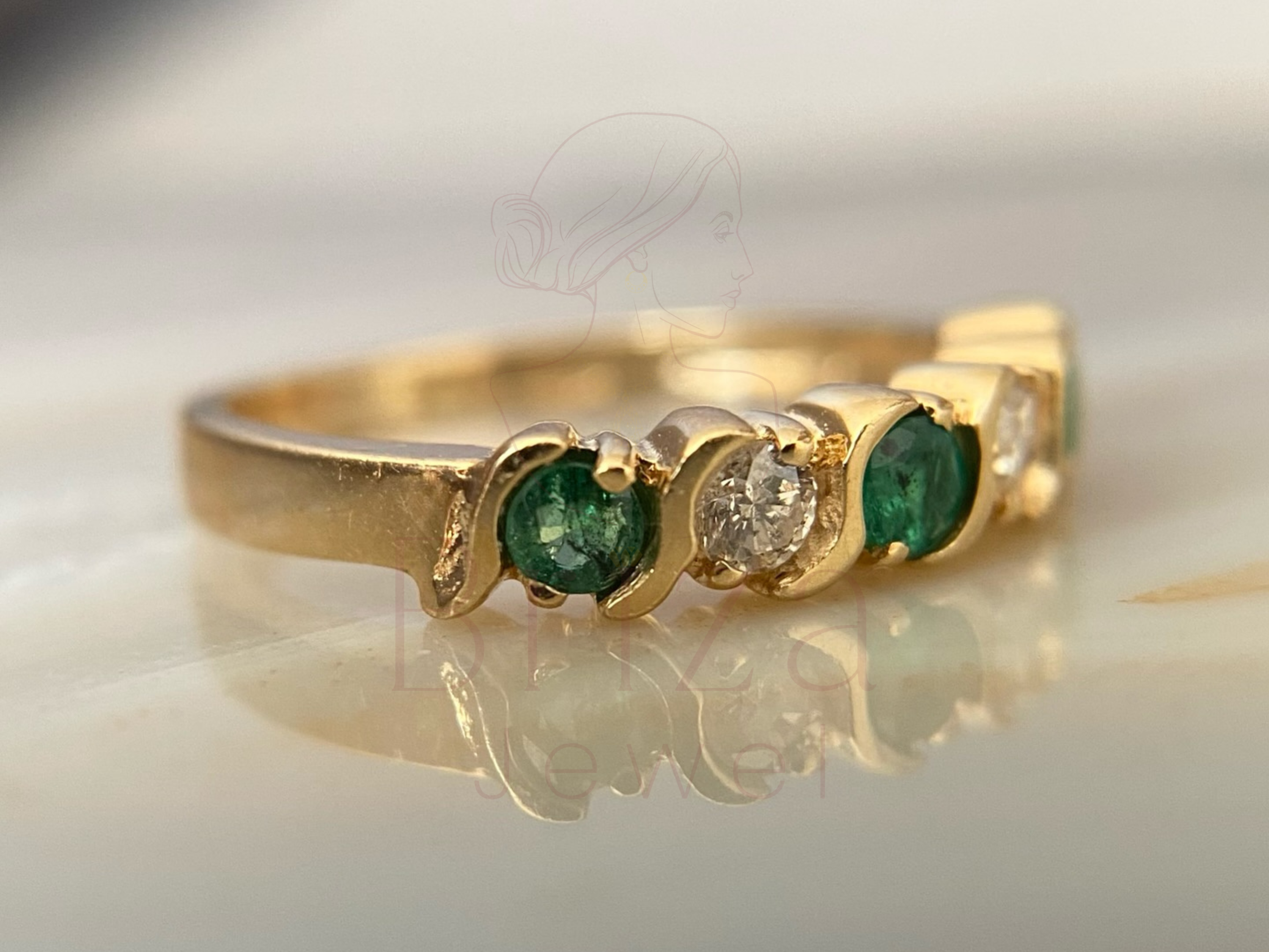 side view of yellow gold band with green gemstone setting