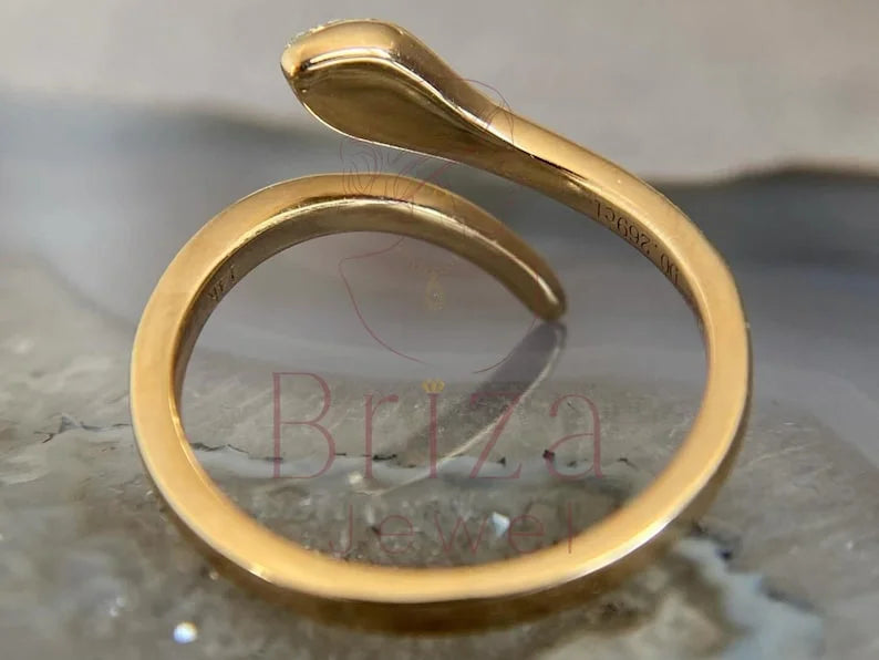 Gold with a unique design on a textured surface, featuring the brand 'Briza Jewel'.