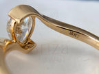 Gold ring with a heart-shaped diamond on a light background