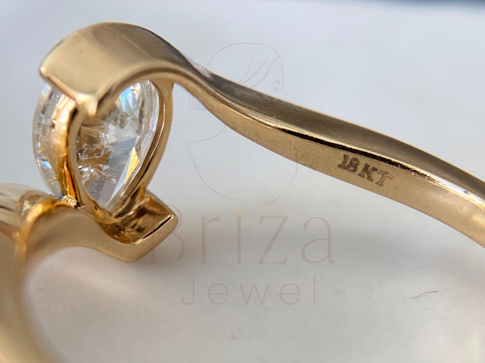 Gold ring with a heart-shaped diamond on a light background