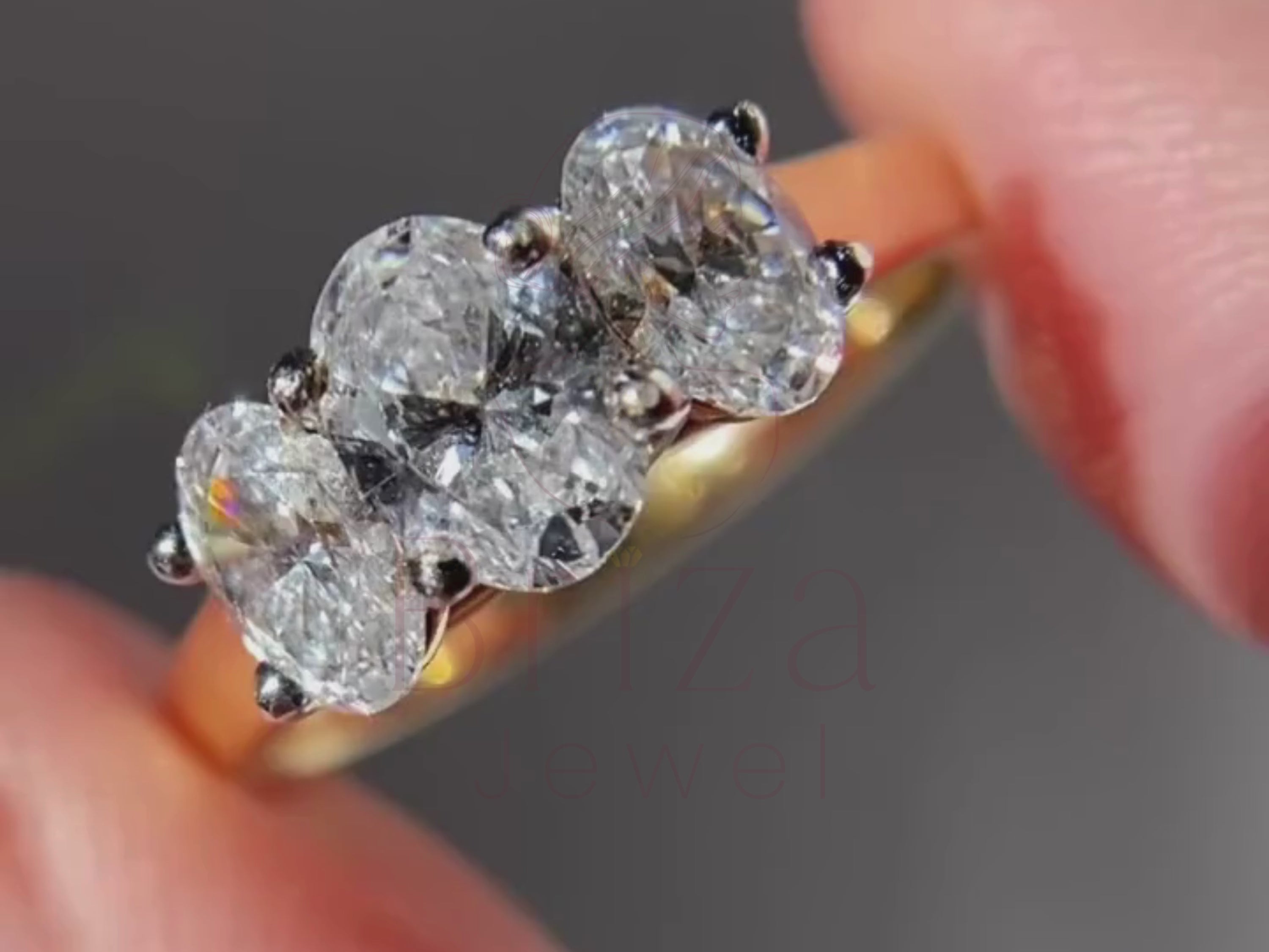 three stone oval engagement ring close-up showing center and side stones