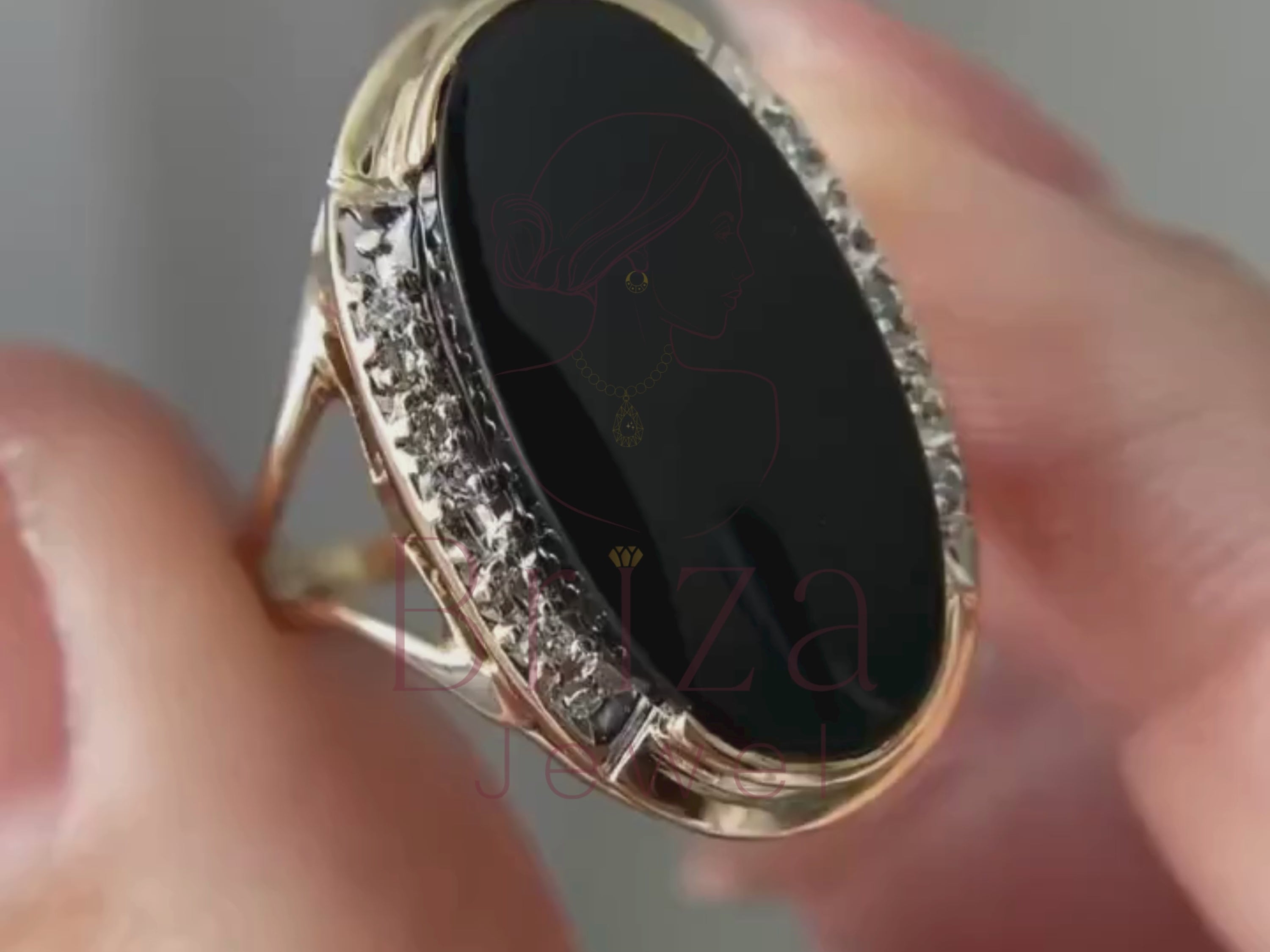 women’s black wedding ring close-up showing oval gemstone detail